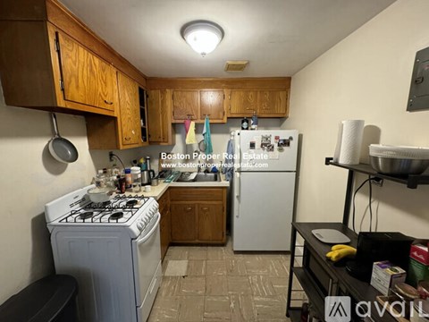 A kitchen with a white stove and a white refrigerator.