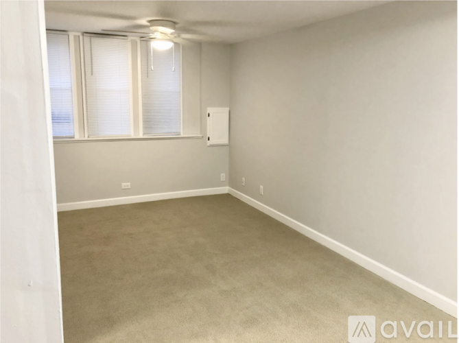A room with a window and a carpeted floor.