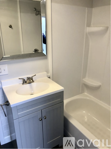 A white sink in a bathroom with a mirror above it.