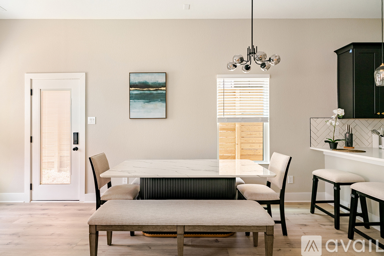 A modern dining room with a white table and chairs.
