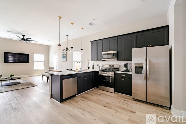 A modern kitchen with black cabinets and stainless steel appliances.