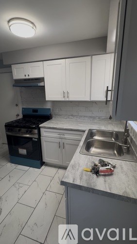 A kitchen with a sink, oven, and cabinets.