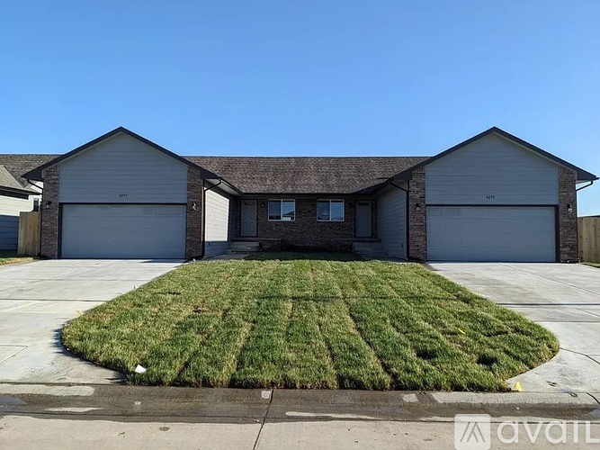 A house with a large front yard and two garages.