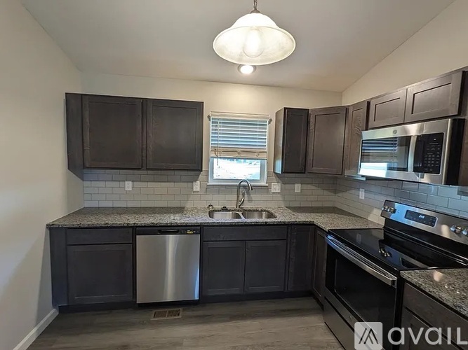 A kitchen with dark brown cabinets and stainless steel appliances.
