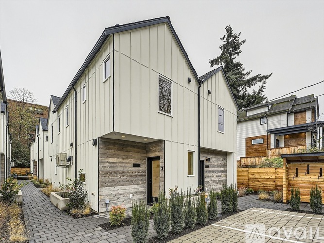 A modern house with a white exterior and a wooden garage door.