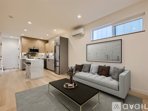 A modern living room with a grey sofa and a coffee table in the center.
