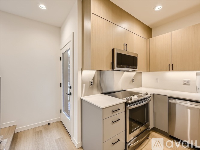 A modern kitchen with wooden cabinets and stainless steel appliances.
