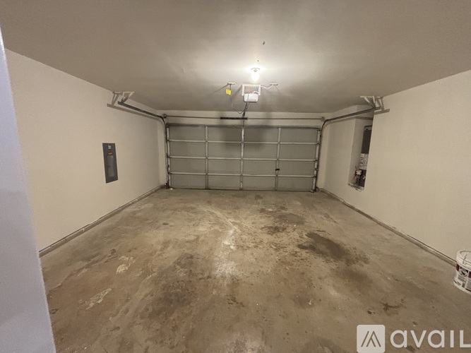 A spacious garage with a concrete floor and a metal shelving unit.