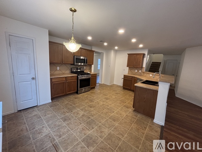 A kitchen with a tile floor and a chandelier hanging from the ceiling.