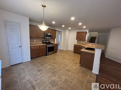 A kitchen with a tile floor and a chandelier hanging from the ceiling.