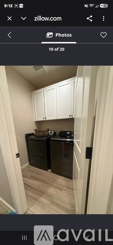 A kitchen with white cabinets and a black refrigerator.