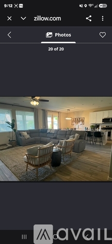 A living room with a grey sofa and a wooden floor.