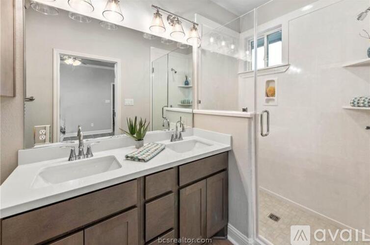 A bathroom with a double sink vanity and a large mirror above it.