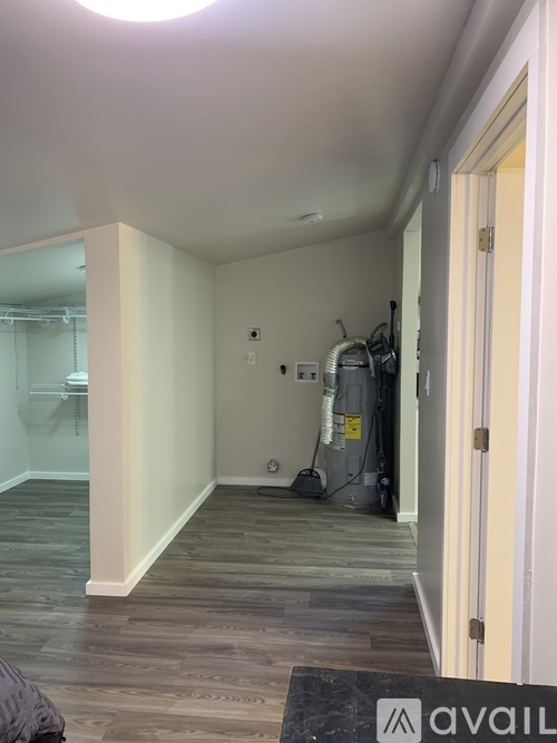 A room with a vacuum cleaner and a wall-mounted fan.