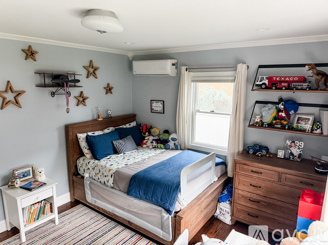 A child's bedroom with a bed, dresser, and toys.