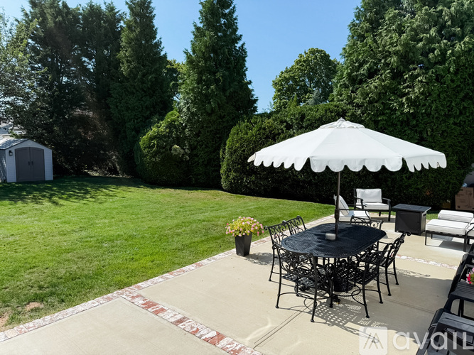 A patio with a table and chairs under an umbrella.