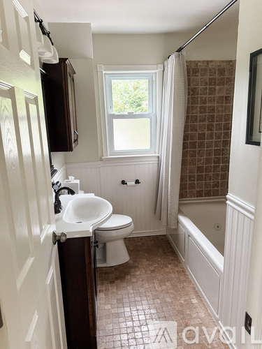 A bathroom with a toilet, sink, and bathtub.