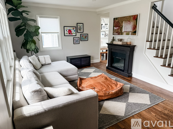 A living room with a grey couch and a black fireplace.