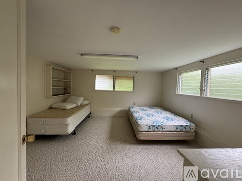 A bedroom with two beds and a carpeted floor.