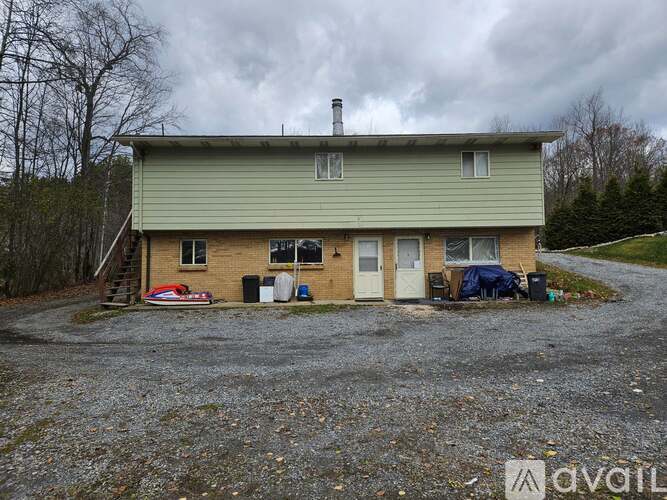 A house with a gravel driveway in front of it.