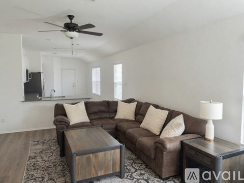 A living room with a brown couch and a wooden coffee table.
