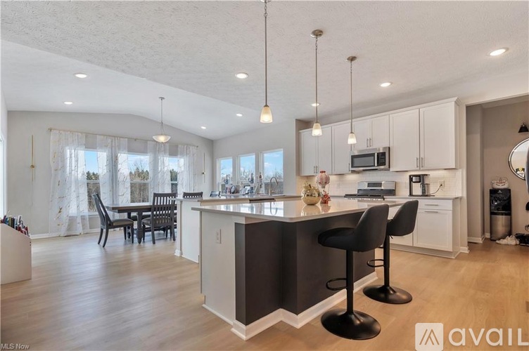 A modern kitchen with a large island and bar stools.