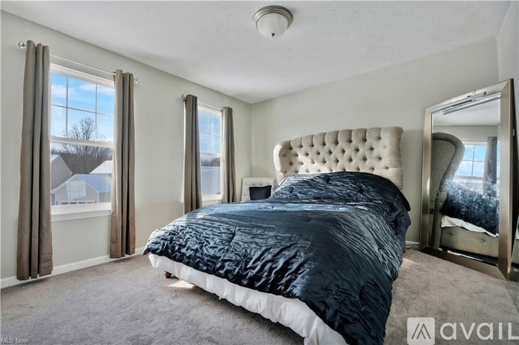 A bedroom with a large bed and a mirror on the wall.
