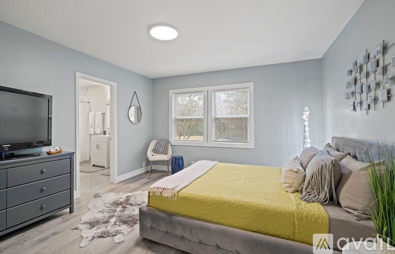 A bedroom with a bed, dresser, and television.