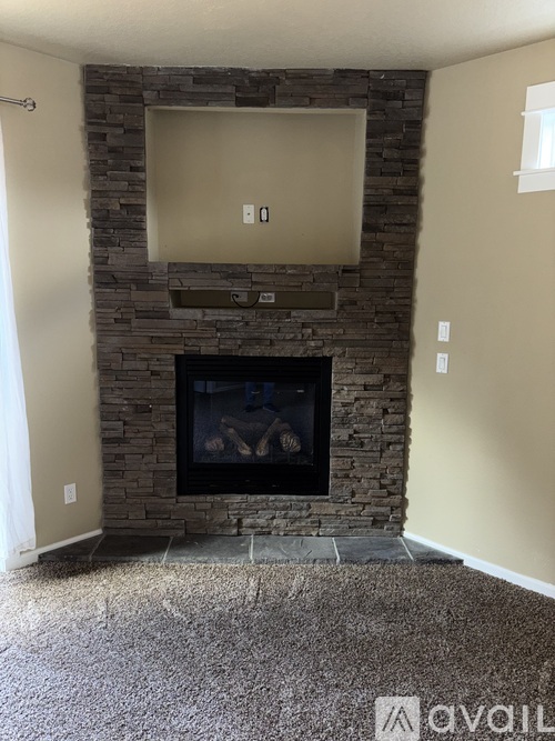A stone fireplace with a flat screen TV above it.
