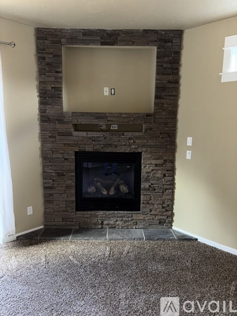 A stone fireplace with a flat screen TV above it.