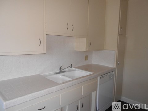 A small white kitchen with a sink and a dishwasher.