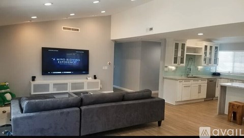 A living room with a grey couch and a television displaying the words "A MIND BLOWING EXPERIENCE".