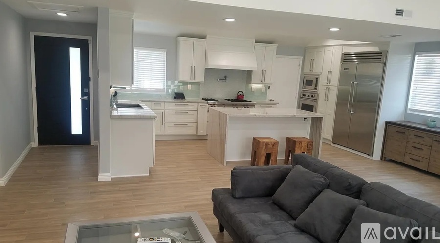 A modern kitchen with a dining area and a living room.