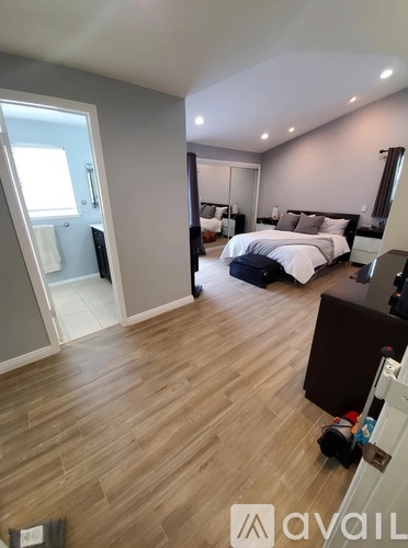 A bedroom with a large bed and a balcony.