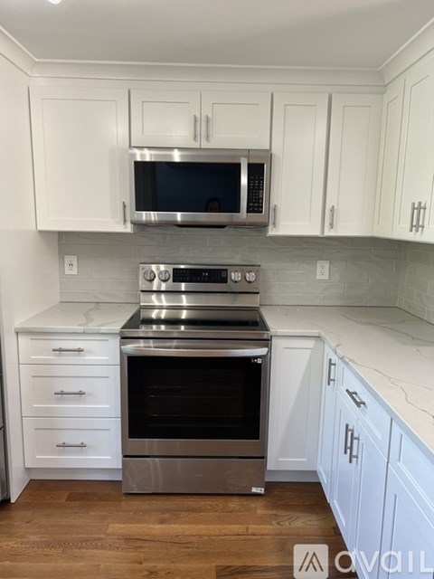 A kitchen with white cabinets and a stainless steel oven.