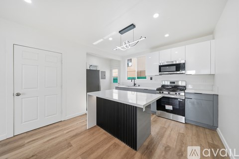 A modern kitchen with a white door and a black counter.