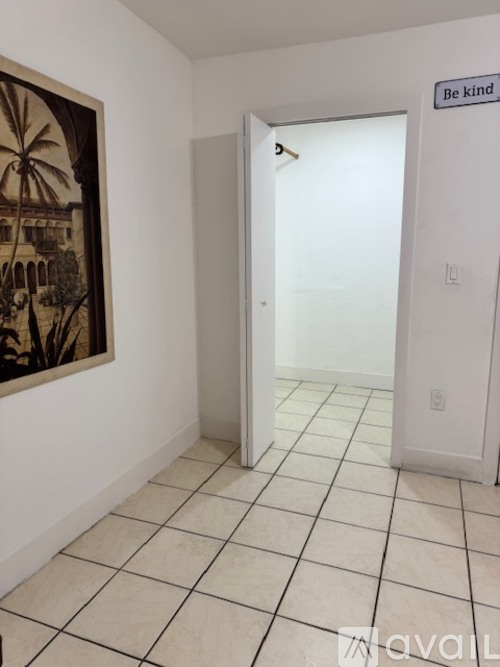 A room with a painting on the wall and a sign that says "Be kind".