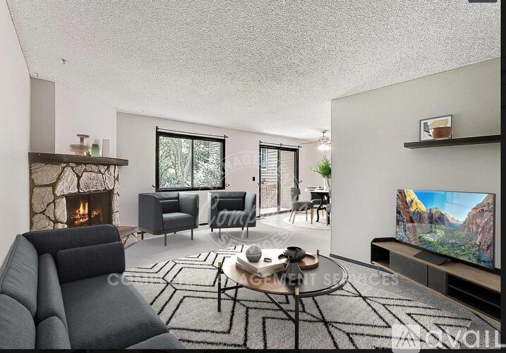 A modern living room with a grey sofa, a fireplace, and a television.