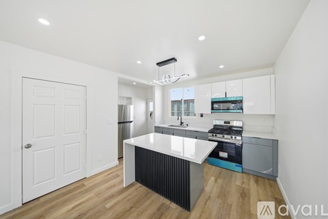 A modern kitchen with a white island and stainless steel appliances.