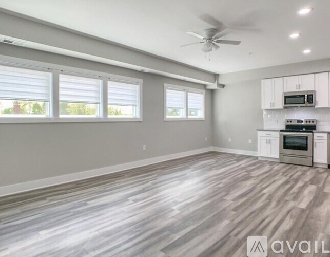 A spacious kitchen with a fan and a microwave on the countertop.