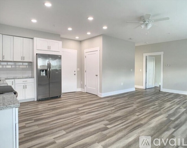 A kitchen with a refrigerator, cabinets, and a countertop.