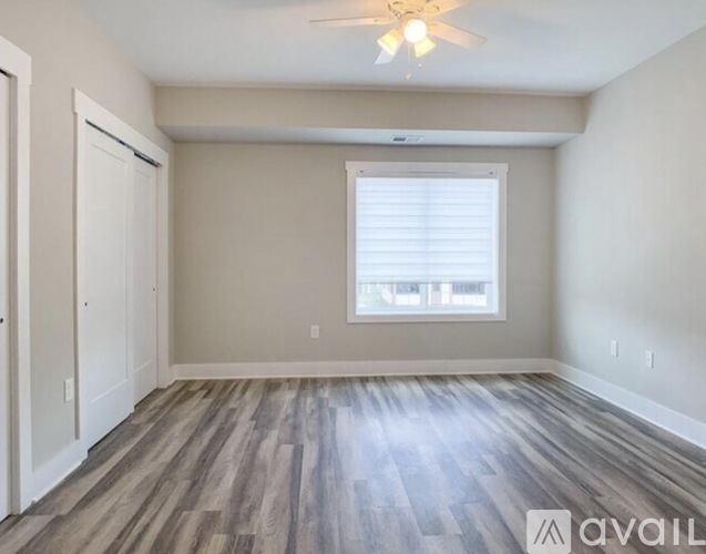 A room with a window and a wooden floor.