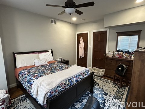 A bedroom with a large bed and a ceiling fan.