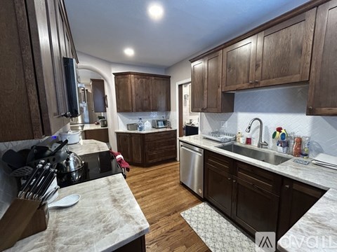 A kitchen with wooden cabinets and a marble countertop.