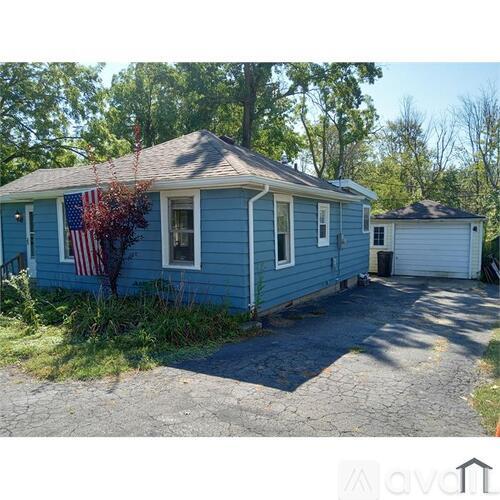 A blue house with a flag on the front and a garage door.