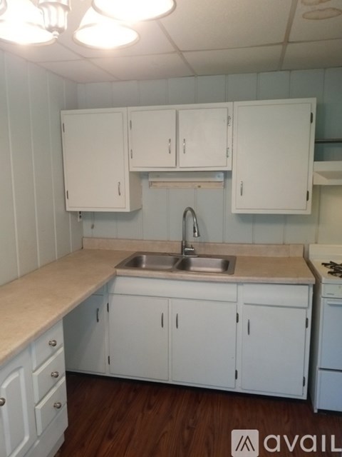 A kitchen with white cabinets and a sink.