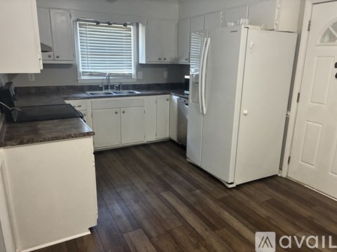 A kitchen with white cabinets and a white fridge.