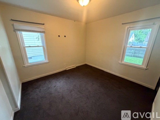 A room with two windows and a carpeted floor.