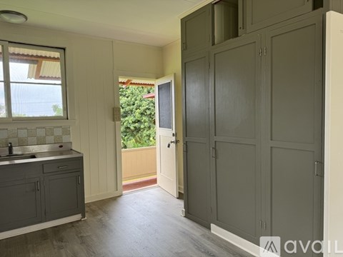A kitchen with grey cabinets and a sink.