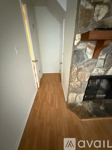 A hallway with a stone fireplace on the right side.
